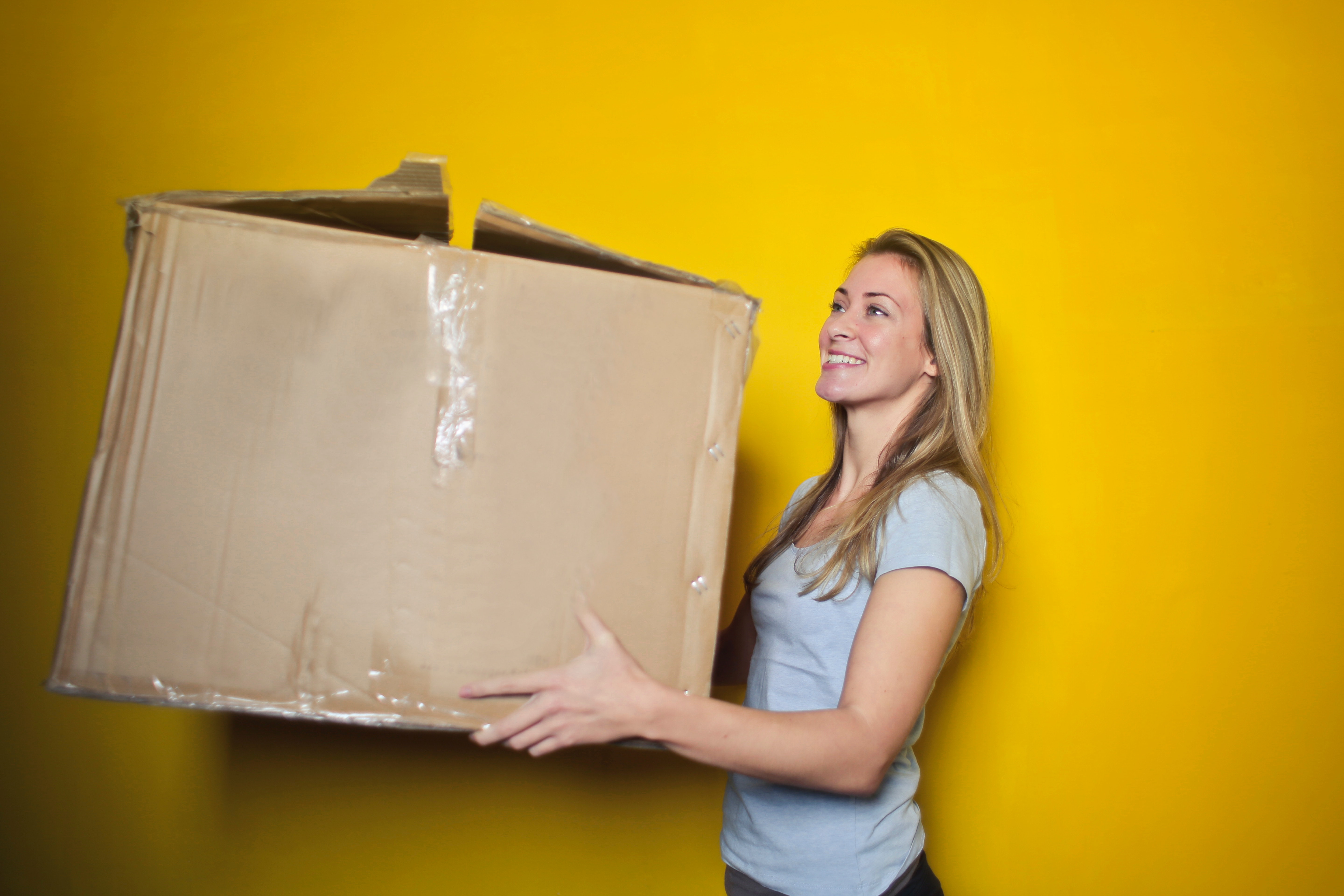 Woman carrying a large cardboard box